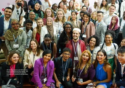 A full-page group photo of young delegates at the pavilion