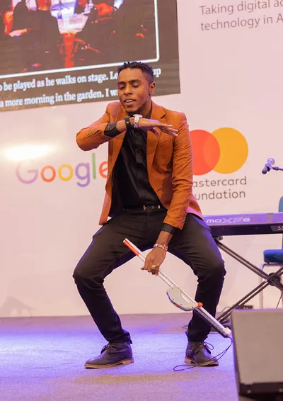 Back cover: a speaker on stage in front of the sponsor backdrop