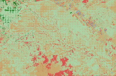 The model's land-cover prediction for Nairobi National Park: mostly pale green and tan, with a faint grid of square tiles and red patches in the south