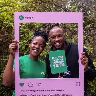 Two Leja users posing with a pink social-media photo frame